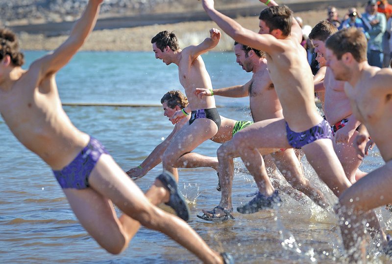 Andrew Ellis, 16, (center) and the “Rhett’s Polar Plungers” team of Fayetteville High School sophomores takes the plunge Saturday during the Beaver Lake Polar Plunge at Prairie Creek recreation area near Rogers. 