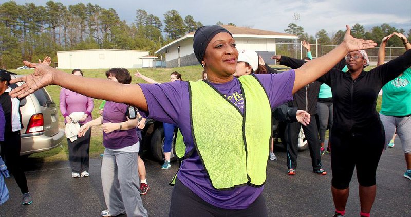Arkansas Democrat-Gazette/CELIA STOREY
Lisa Kirk warms up with other participants in the Women Run Arkansas running and walking clinic at J.A. Fair High School in Little Rock on March 31.