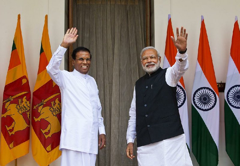 Sri Lanka’s President Maithripala Sirisena, left, and Indian Prime Minister Narendra Modi wave during a photo opportunity in New Delhi, India, Monday, Feb. 16, 2015. Sri Lanka's new leader is underlining India's importance as a regional ally by making it his first official foreign destination as president, following years of uneasy relations with New Delhi and international pressure to speed up post-civil war reconciliation efforts at home.  (AP Photo/Saurabh Das)