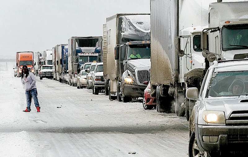 A driver steps out of his vehicle to peer around traffic in an effort to see why eastbound traffic on Interstate 40 near mile marker 163 was stopped; an 18-wheeler was stuck. See more photos at arkansasonline.com/galleries