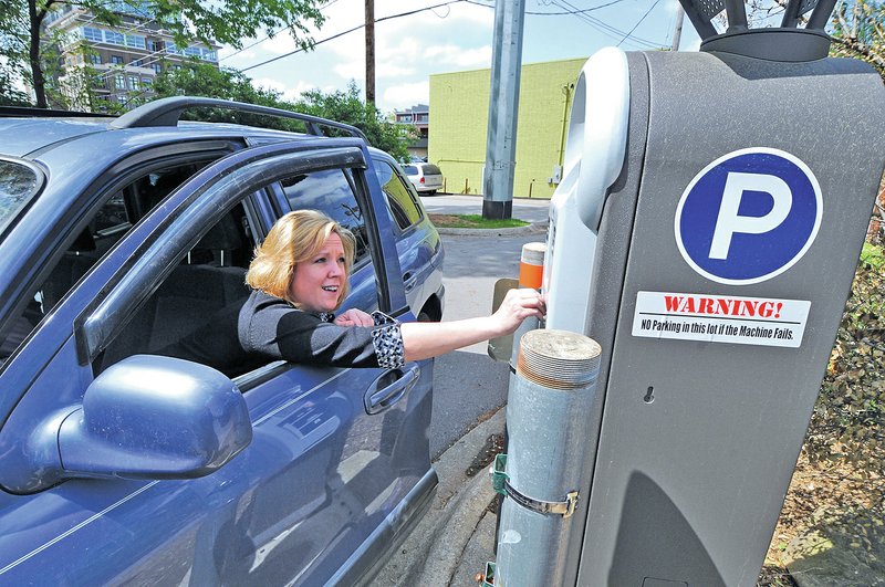 File Photo/J.T. WAMPLER Jamie Daniels of Farmington pays to park in a Fayetteville lot in April 2010. The City Council is looking at changing the kiosk at the West Avenue lot.