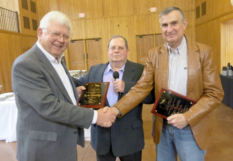 Photo by Susan Holland Pharmacists Ron Teasley, left, and Ken Austin, right, were chosen as Gravette Citizens of the Year for 2014 at the Chamber of Commerce banquet. They were presented with plaques acknowledging their many contributions to the city of Gravette by Rickie Stark, treasurer of the Chamber.