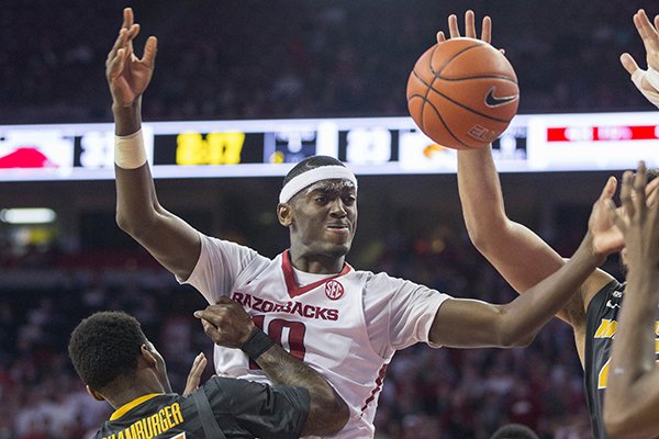 Arkansas forward Bobby Portis, center, passes the ball as Missouri guard Keith Shamburger, left, defends during the first half of an NCAA college basketball game on Wednesday, Feb. 18, 2015, in Fayetteville, Ark. (AP Photo/Gareth Patterson)