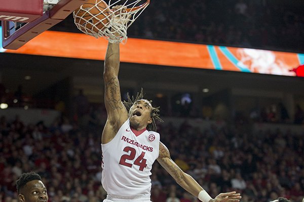 Arkansas guard Michael Qualls, center, dunks after running by Missouri guard Keith Shamburger, right, during the second half of an NCAA college basketball game on Wednesday, Feb. 18, 2015, in Fayetteville, Ark. (AP Photo/Gareth Patterson)