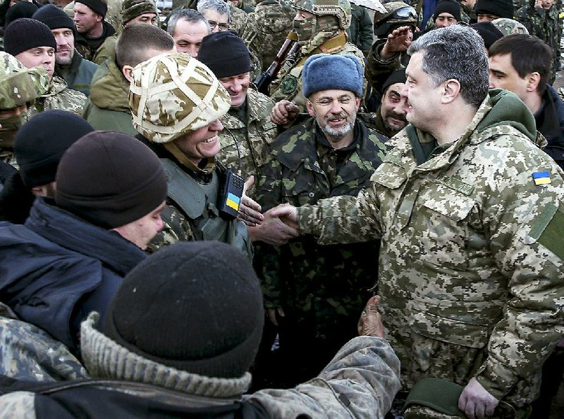 Ukrainian President Petro Poroshenko (right) greets Ukrainian servicemen Wednesday in the town of Artemivsk. Poroshenko traveled to eastern Ukraine after ordering soldiers to leave Debaltseve. 