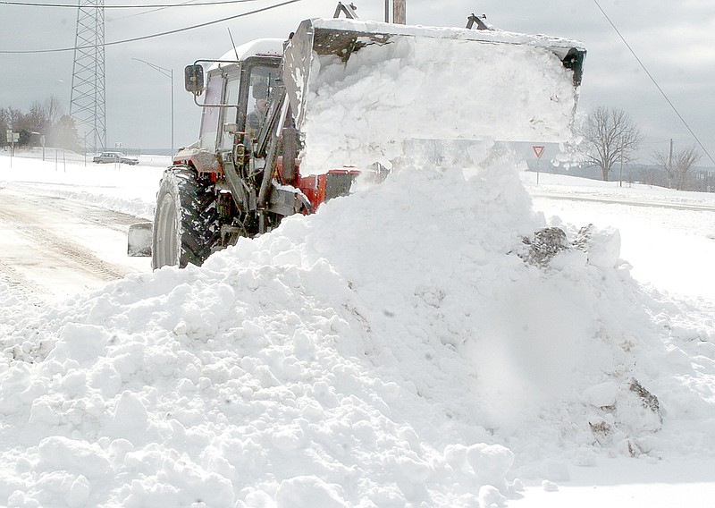 RICK PECK MCDONALD COUNTY PRESS Kelly Kissire clears a parking lot in Pineville Monday following the season&#8217;s first snowstorm that hit late Sunday night and early Monday morning.