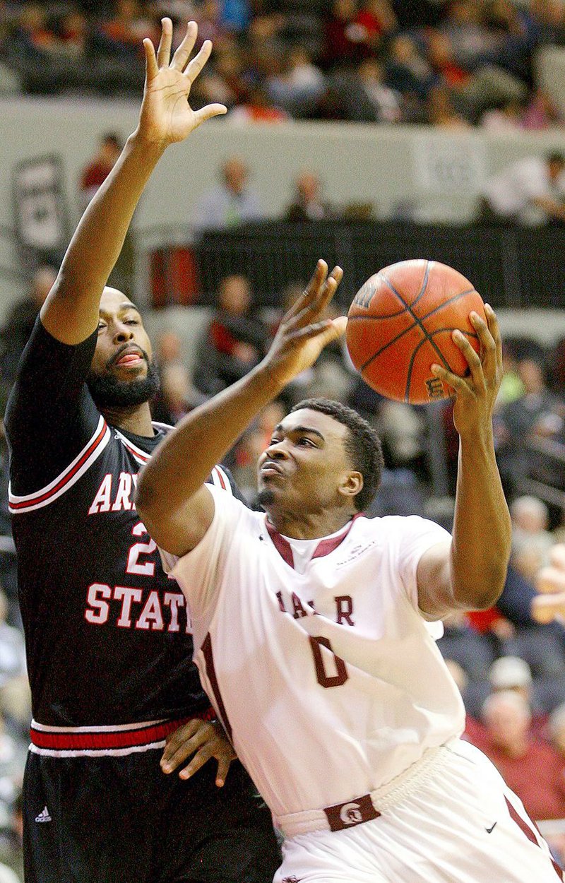 UALR forward Roger Woods (right) drives to the basket against ASU’s Anthony Livingston during Thursday’s game in Little Rock. Woods finished with 11 points.