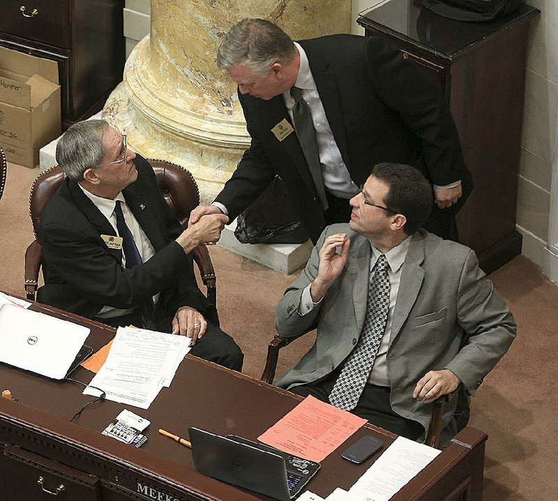 State Rep. Jack Ladyman, R-Jonesboro (left), is congratulated Thursday by Rep. Donnie Copeland, D-North Little Rock, after Ladyman’s legislation on water fluoridation passed the House. State Rep. Stephen Meeks, R-Greenbrier (right), also backed the bill which lets local water systems — instead of the state — decide whether to add fluoride. 