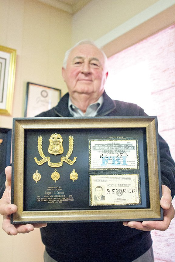 Eugene Crouch holds up his badge and identification from his time with the FBI. Crouch had a 25-year career with the Bureau, which took him to Philadelphia, New York City, Oklahoma City and Grand Rapids, Michigan, and South Dakota before he returned to Little Rock.