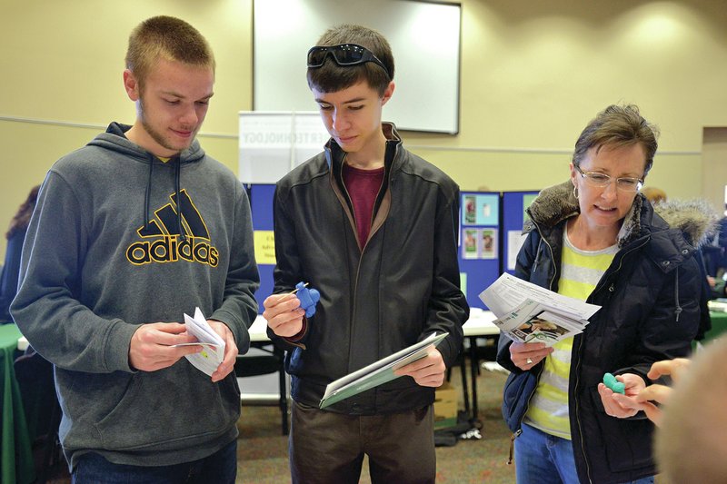 NWA Democrat-Gazette/BEN GOFF Mitchell Sanders, 17, (from left) of Bentonville looks at samples of 3D printed plastic objects Thursday with friend Robby Jeffries, 15, of Rogers and his mother Valarie Jeffries during an event for home-school families to learn about concurrent enrollment opportunities at the Shewmaker Center at Northwest Arkansas Community College in Bentonville.