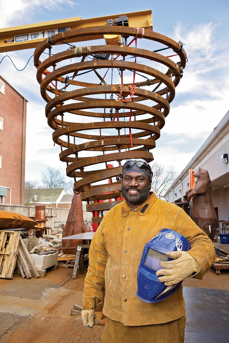 Bryan Massey Sr., an art professor at the University of Central Arkansas in Conway, stands in front of a 15-foot-high cyclone that he was commissioned to create for Russellville High School, the home of the Cyclones.