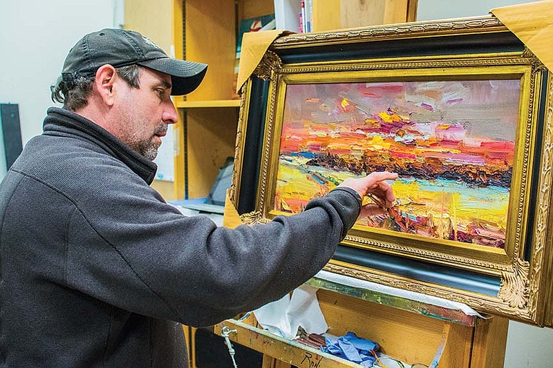 Benton artist Matt Coburn works on an oil painting of a sunset in his studio space in The Art Group Galley in Little Rock. Coburn will bring more than 70 of his paintings to the Delta Visual Arts Show in Newport.