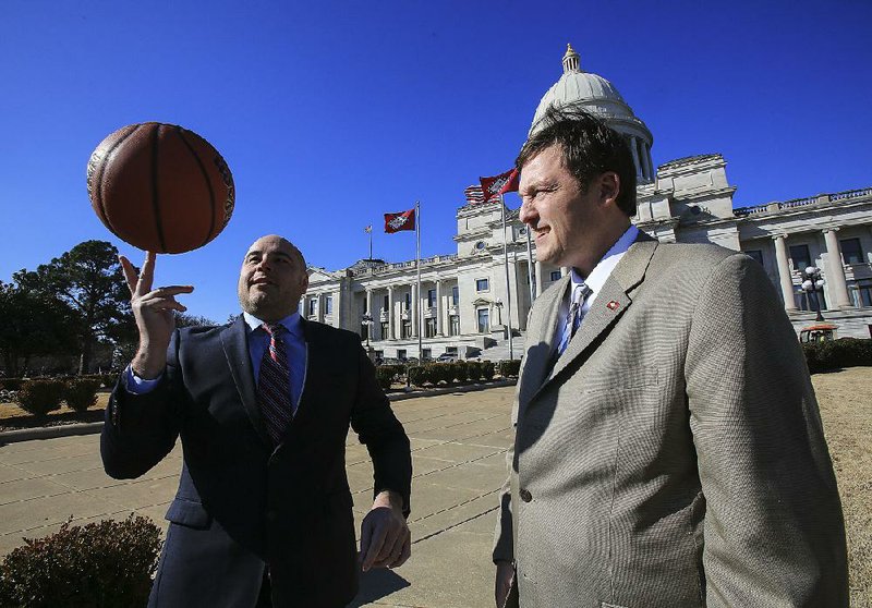 State Sen. Jeremy Hutchinson demonstrates spinning a basketball for House Speaker Rep. Jeremy Gillam. Together, their hooping (and hollering?) will propel the annual House-Senate game, Hoops for Kids’ Sake.