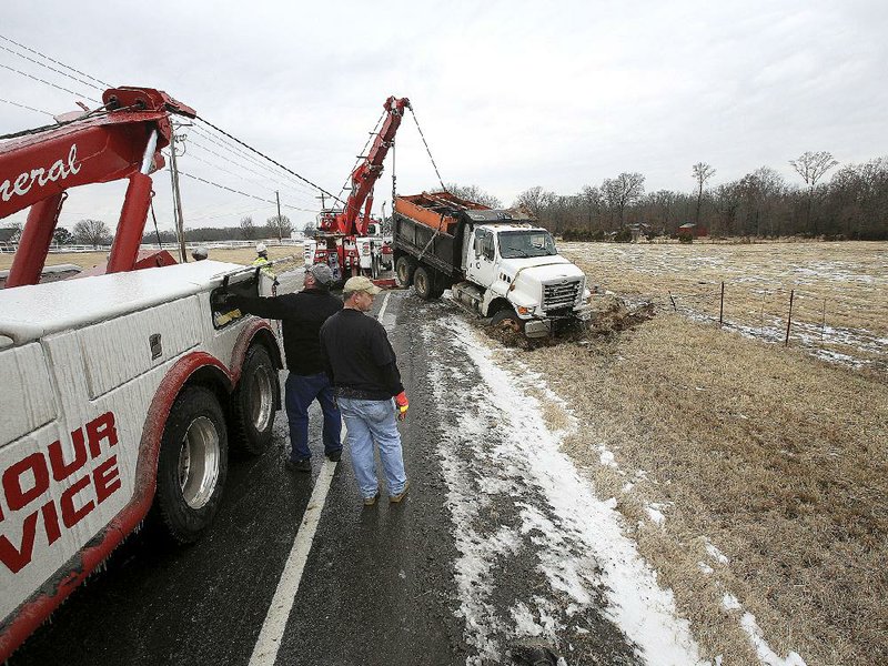 Wrecker crews work to recover an Arkansas Highway and Transportation Department salt truck after it overturned Friday morning on Arkansas 36 west of Searcy. No one was injured in the accident. 