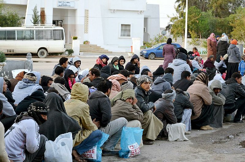 Egyptian workers wait Friday at the Ras Jdir border crossing between Libya and Tunisia. Nearly 200 Egyptians have fled Libya in recent days in fear for their safety. Egypt has said it will send planes to get them home.  