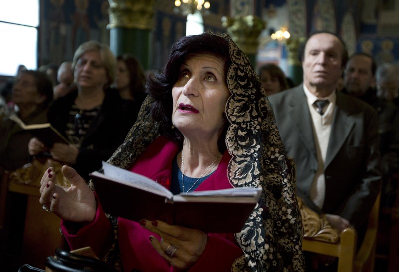 In this Sunday, Feb. 8, 2015 photo, Jordanian Orthodox Christians pray during Sunday Mass service at the Presentation of the Lord Church, in Amman, Jordan. At a recent Sunday mass, Arab Christians enthusiastically joined in the ancient chants and prayers of their faith: until the name of their spiritual leader was invoked. Unworthy, unworthy, unworthy, some called out in unison, their disdain aimed at Theophilos III, the Greek Orthodox patriarch of Jerusalem and leader of some 220,000 Arab Christians in Jordan, Israel and the Palestinian territories. 