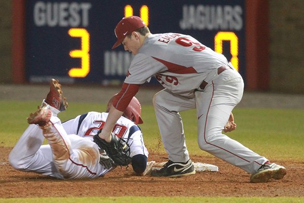 Arkansas first baseman Clark Eagan attempts to tag a base runner during the fourth inning of a game Saturday, Feb. 21, 2015, at Stanky Field in Mobile, Ala. 