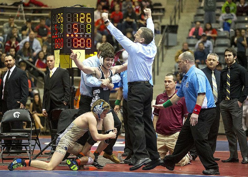 Woodlawn Coach Dudley Hume (right) celebrates as his son, Tyson Hume, is declared the winner in the 126-pound weight class championship match in the Class 1A-5A high school wrestling state tournament at the Jack Stephens Center. Hume defeated Pulaski Academy’s Michael Crockett (left) by decision, 8-6. More photos available at arkansasonline.com/galleries. 
