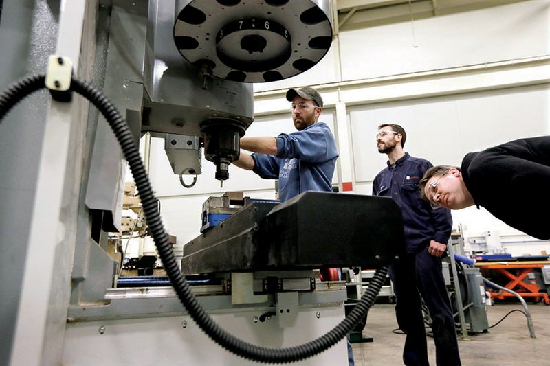 Brad Bancroft (from left) operates a mill as Nate Joseph and Adam Woodhams look on in the advanced precision machining class at Lansing. Mich., Community College.