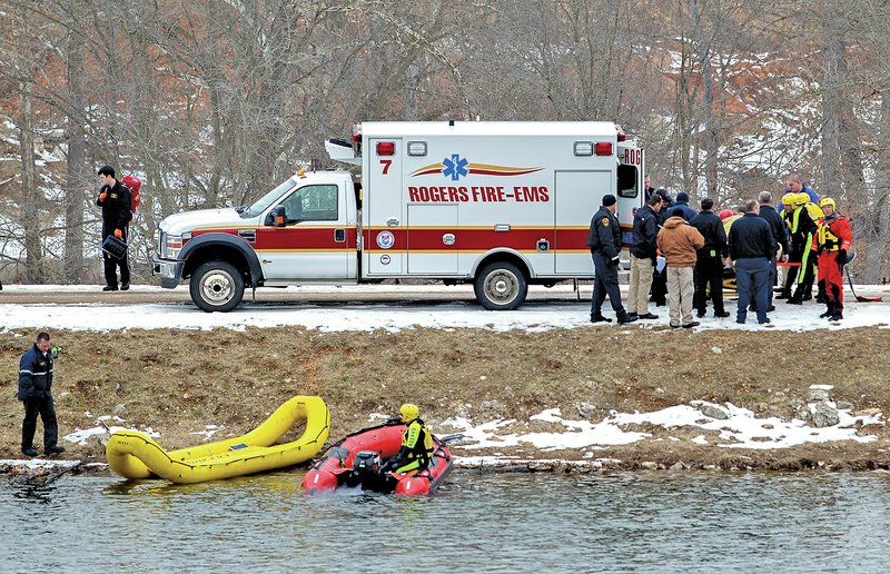 NWA Democrat-Gazette/JASON IVESTER Search and rescue members load a teen into an awaiting ambulance Friday at Lake Atalanta in Rogers. Trenton Whitfield, 17, of Rogers drowned after being trapped in a vehicle that slid on the icy road into the lake.