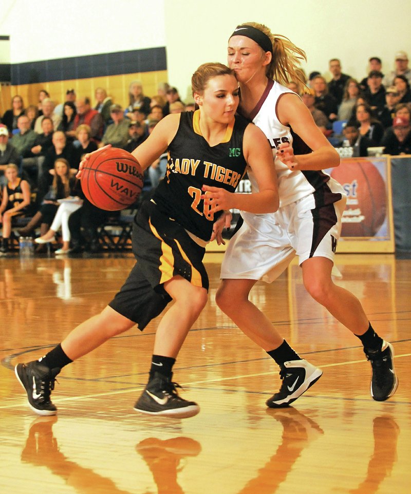 NWA Democrat-Gazette/Michael Woods &#8226; @NWAMICHAELW Camree Bartholomew of Prairie Grove drives to the hoop Saturday past Huntsville defender Emily Phillips during the 4A-1 District Tournament at Shiloh Christian in Springdale.