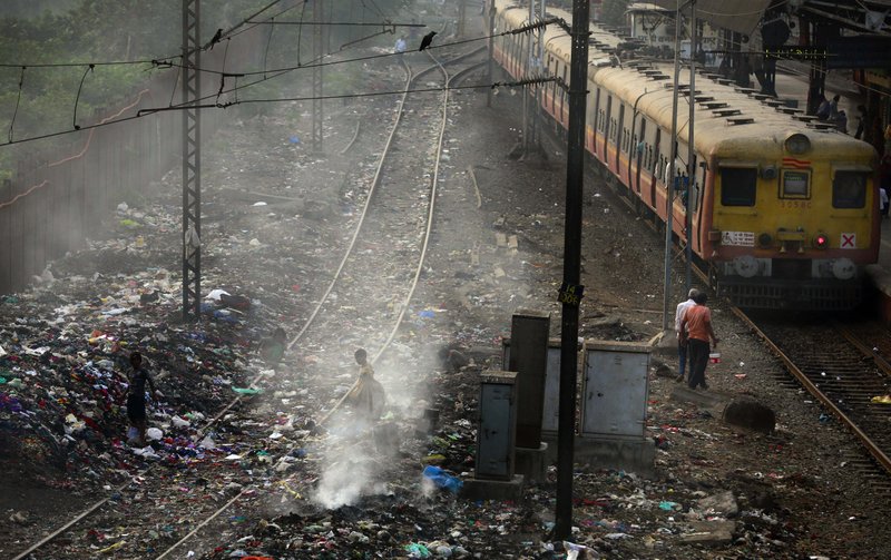  In this Monday, Jan 26, 2015 file photo, a local train moves past burning garbage at a local train station in Mumbai, India. Indias filthy air is cutting 660 million lives short by about three years, while nearly all of the countrys 1.2 billion citizens are breathing in harmful pollution levels, according to research published Saturday, Feb. 21, 2014. While New Delhi last year earned the dubious title of being the worlds most polluted city, the problem extends nationwide, with 13 Indian cities now on the World Health Organizations list of the 20 most polluted.