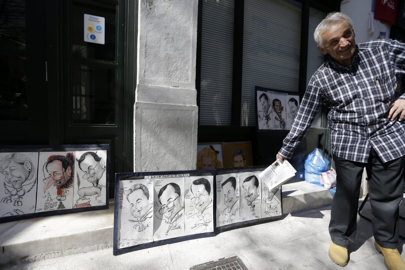 A street artist shows fun caricature portraits of various political leaders in the traditional Plaka district of Athens on Saturday, Feb. 21, 2015. Greece's government starts working on drafting a series of economic reforms it must present to the other euro zone finance ministers on Monday, as part of an agreement reached Friday to extend the country's European loan agreement. 