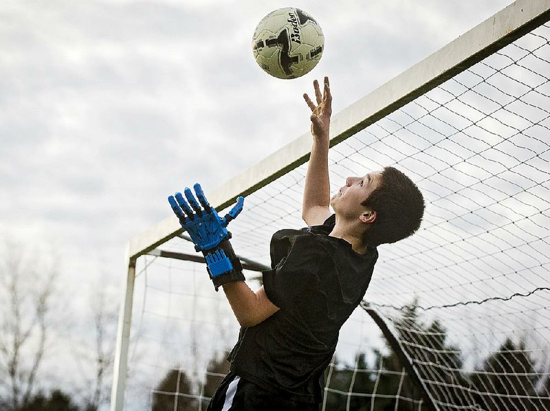 Dawson Riverman, 13, who hopes to become a goalkeeper on his school team in Aloha, Ore., plays soccer with friends Feb. 11 using the 3-D printed prosthetic hand provided for him by volunteers with E-nable.