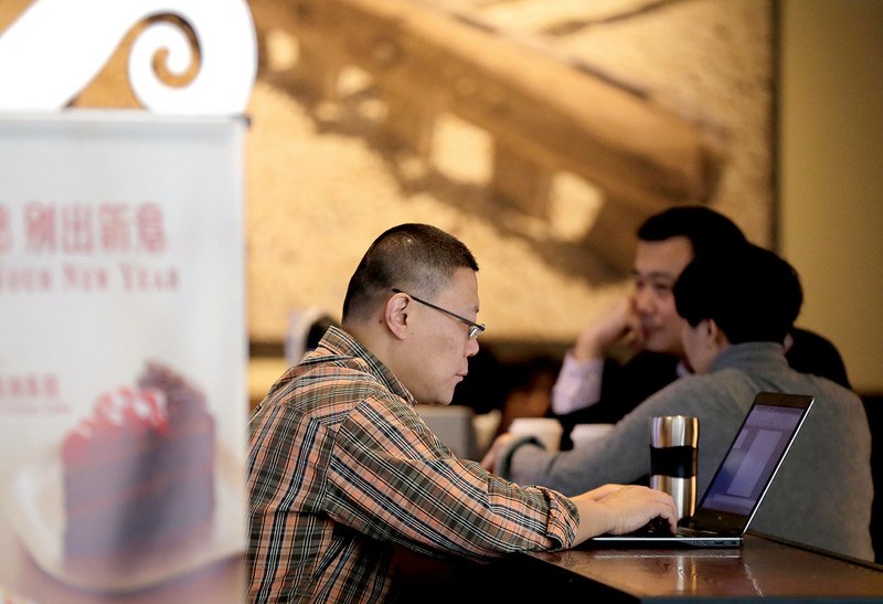 A man surfs the Internet on his laptop at a Starbucks cafe in Beijing last week. Controls on what people in China can see online are growing. 