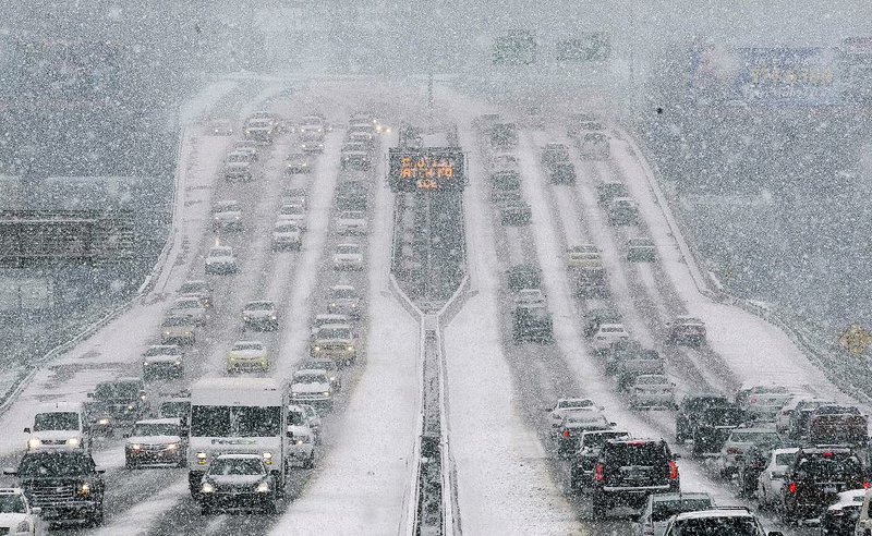 Traffic backs up Monday afternoon along Interstate 630 as drivers leave downtown Little Rock in heavy snowfall. 