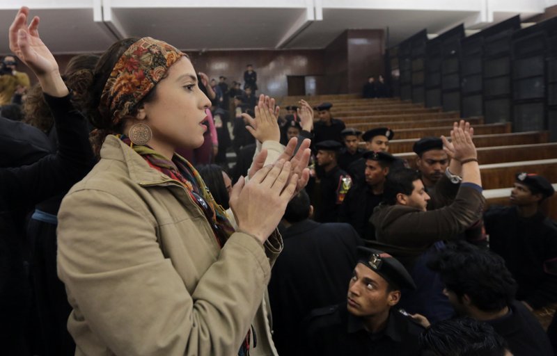 Supporters of 21 activists on trial stand on wooden benches chanting, Down with military rule, after they were sentenced to prison terms over an unauthorized street protest in 2013, in a Cairo court, Egypt, Monday, Feb. 23, 2015. The court sentenced Alaa Abd el-Fattah, an icon of the country's 2011 revolt to five years in prison Monday, showing authorities' determination to continue to stifle dissent despite promises by its president to release "wrongly jailed youths." Another defendant, Ahmed Abdel Rahman, was also given five years. The others were sentenced to three years.