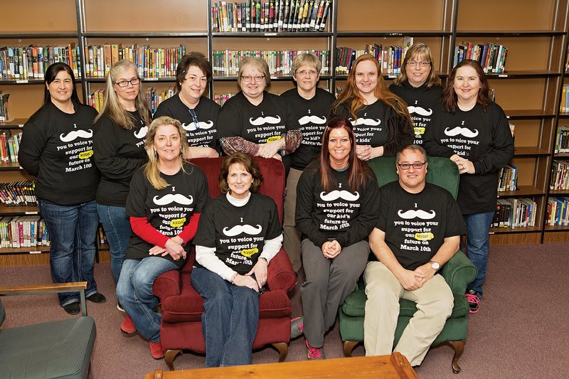 Dover Middle School teachers and staff wear T-shirts in support of the upcoming special election for a millage increase for the school district. The shirts are printed with “I mustache (must ask) you to voice your support for our kids’ future on March 10.” Shown in the front row, from left, are Kay New, Karen Hill, Amanda Bryan and Principal Donny Forehand; and in the back row, Vanessa George, Rhonda Parson, Rhonda Fairfield, Kim Williams, Catherine Pittman, Christi Jones, Paula Roberts and Suzy Pennington.