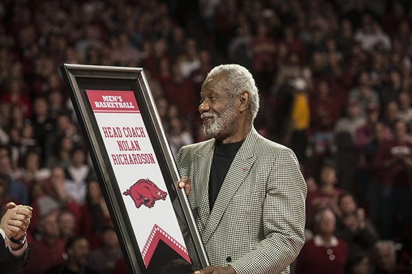 Former Arkansas head coach Nolan Richardson accepts a replica of his banner unveiled Tuesday, Feb. 24, 2015, at Bud Walton Arena in Fayetteville.