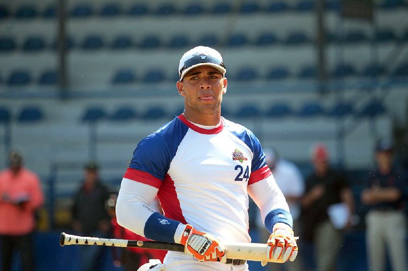 In this Nov. 12, 2014 photo, Cuban baseball player Yoan Moncada prepares for an exhibition game for major league scouts, in the Enrique Torrebiarte Stadium in Guatemala City. 