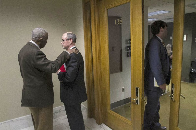 Rep. John Walker (left), D-Little Rock, talks with University of Arkansas System President Donald Bobbitt on Tuesday after the House Education Committee approved a plan to exempt the system’s online university from some requirements traditional colleges must meet.