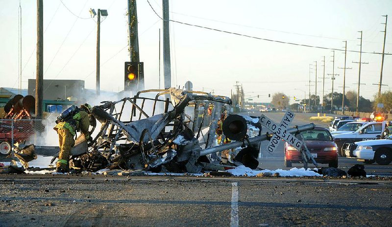 A firefighter works around the burned wreckage of a truck that was hit by a commuter train Tuesday in Oxnard, Calif. 