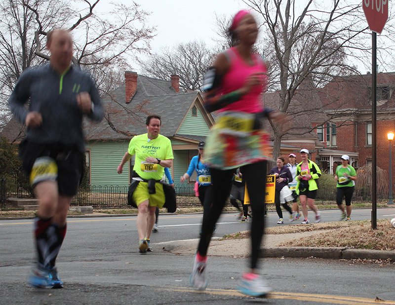 Keith Landers (No. 1787) and other participants in the Little Rock Marathon's early start round the corner of Ninth and Commerce in the 2014 Little Rock Marathon.