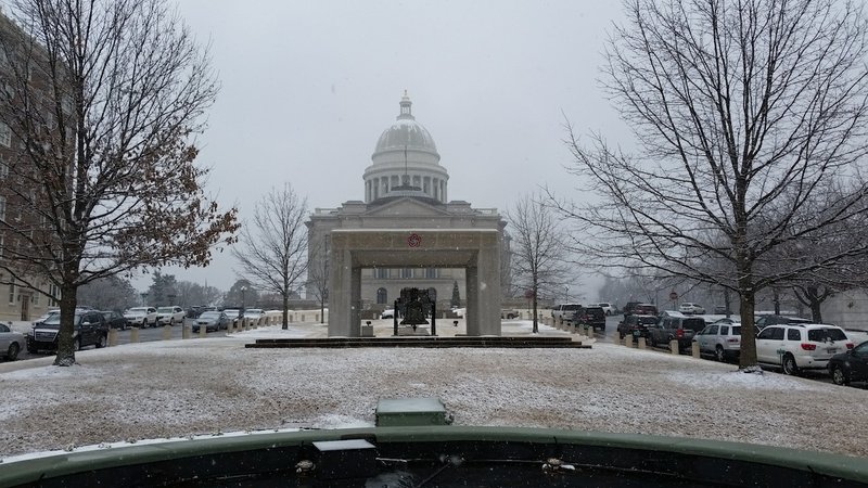 Snow falls outside the state Capitol on Wednesday afternoon. Arkansas state offices closed at noon after a winter storm made its way into the state. 