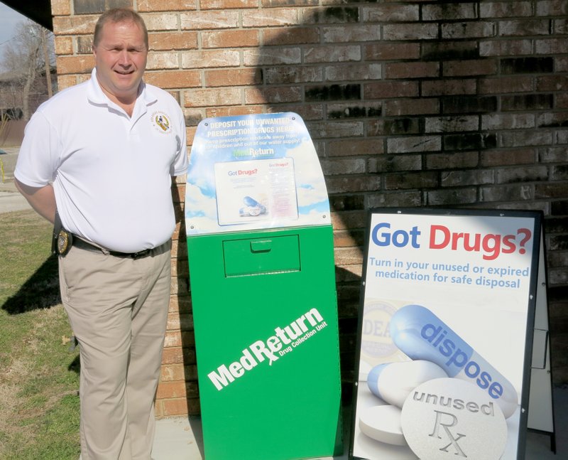 Photo by Susan Holland Andy Bower, Gravette police chief, stands beside the MedReturn Drug Collection Unit installed in front of the Gravette Police Station. Bower says a drug take-back collection is planned for April but the unit is available anytime. Persons may bring unused or unwanted drugs any time, seven days a week, 24 hours a day, for disposal.