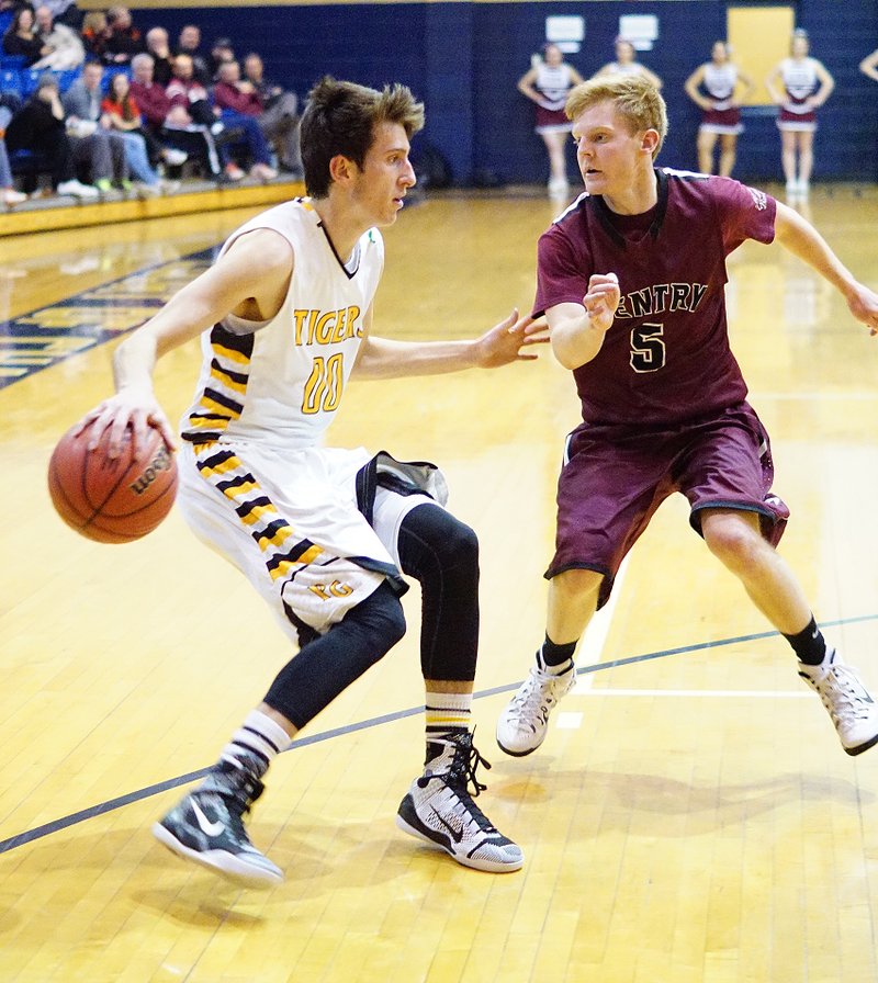 Photo by Randy Moll Tanner Pursell, Prairie Grove senior, attempts to move the ball around Ryan Hockenberry, Gentry senior, during district tournament play at Shiloh Christian in Springdale on Thursday, Feb. 19, 2015.