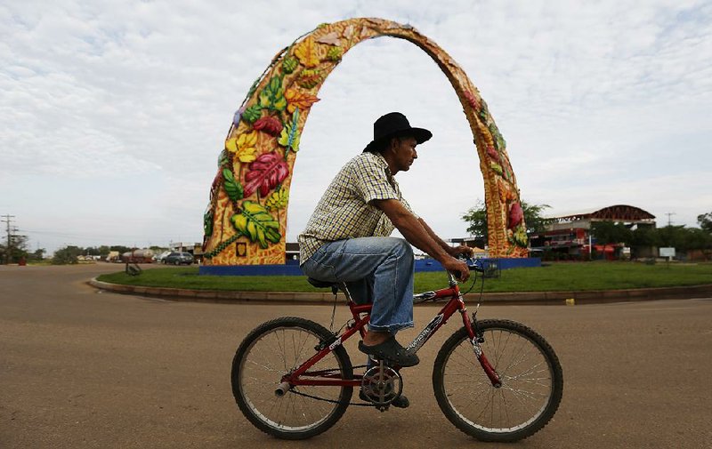 A man rides around the $1 million concrete entrance arch at Puerto Gaitan, Colombia, earlier this month. The Door to Paradise artwork tells the biblical tale of Adam and Eve. 