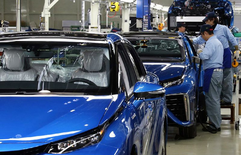Workers assemble a Mirai hydrogen fuel cell-powered car at Toyota’s Motomachi plant Tuesday. Toyota will build 700 of the cars this year and up to 2,000 next year.