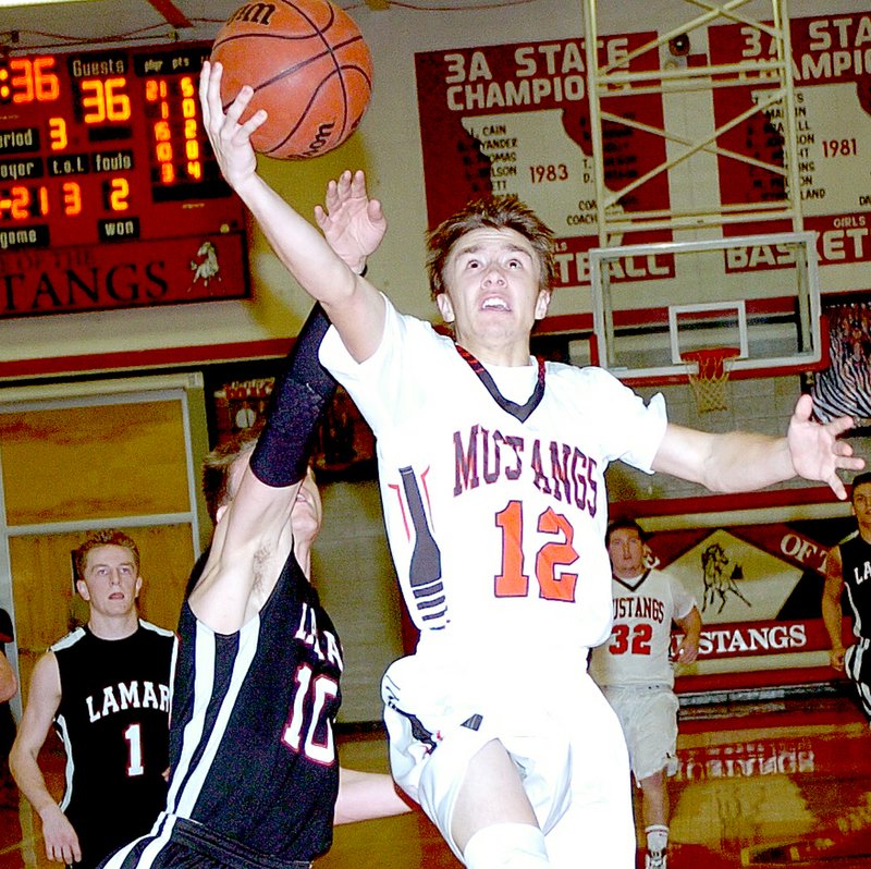 RICK PECK MCDONALD COUNTY PRESS McDonald County&#8217;s Max Dill gets by Lamar&#8217;s Ben Kluhsman for a layup in the Mustangs 63-54 win Feb. 19 at MCHS.