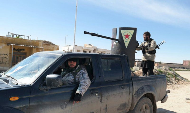 In this image posted on a militant social media account by the Al-Baraka division of the Islamic State group on Tuesday, Feb. 24, 2015, Islamic State militants ride in a Kurdish popular protection unit (YPG) vehicle captured during fighting in Tal Tamr, Hassakeh province, Syria. Fierce fighting between Kurdish and Christian militiamen and Islamic State militants is continuing on Wednesday, Feb. 25 in northeastern Syria where the extremist group recently abducted at least 70 Christians. 