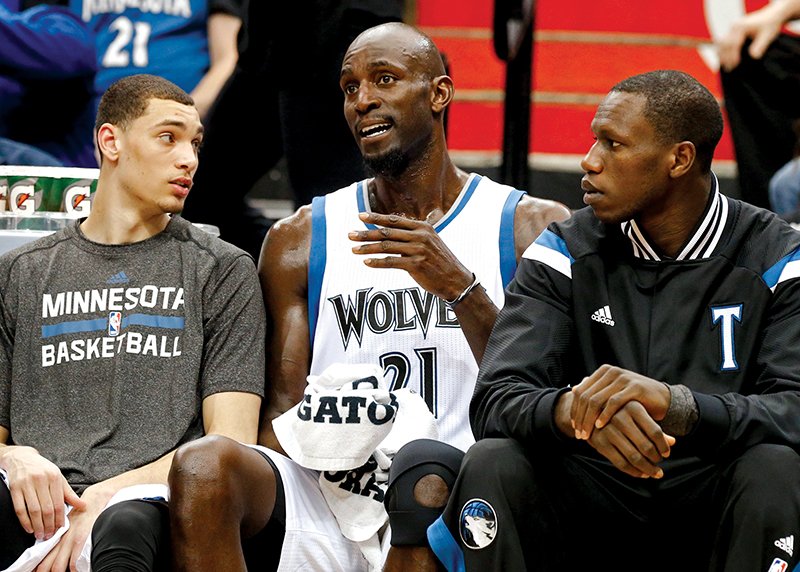 The Associated Press LOOK WHO'S BACK: Kevin Garnett, center, in his first game back with the Minnesota Timberwolves, chats on the bench with rookies Zach LaVine, left, and Andrew Wiggins in the first quarter of Wednesday night's game against the Washington Wizards. Garnett was reacquired in a trade with Brooklyn last week.