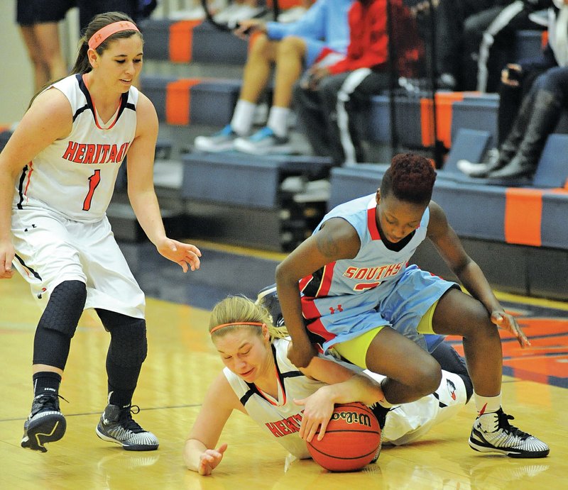 Emilie Jobst (center) of Rogers Heritage and Shaniah Bishop (right) of Fort Smith Southside collide Thursday while reaching for a loose ball as Sara Giesen looks on during the first half in Rogers.