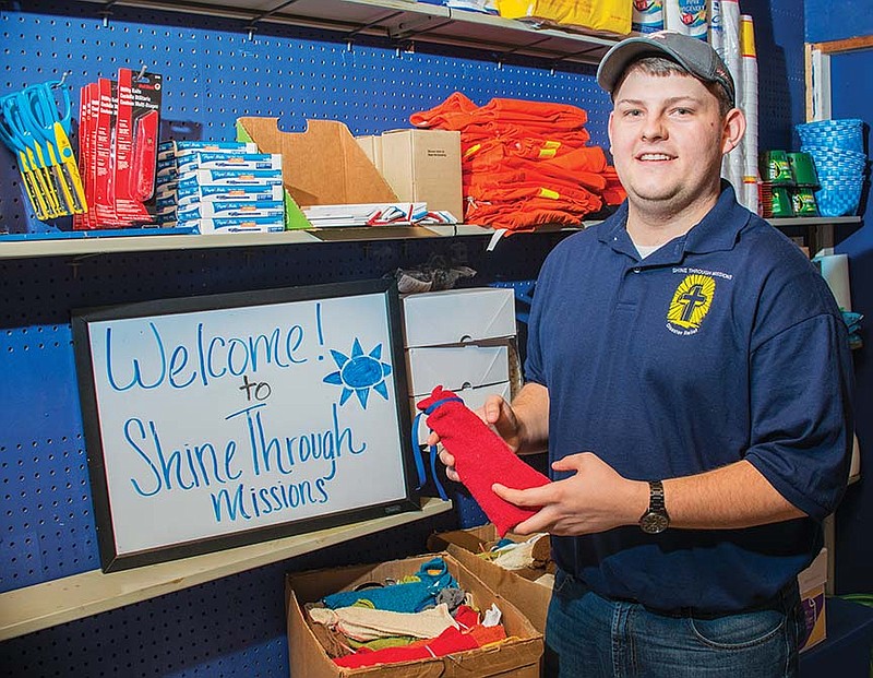 Brett Bagwell, founder of Shine Through Missions Inc. of Arkadelphia, holds a travel pack, a grouping of essential hygiene products that the organization hands out to victims of tornadoes or during other times when the packs are needed.