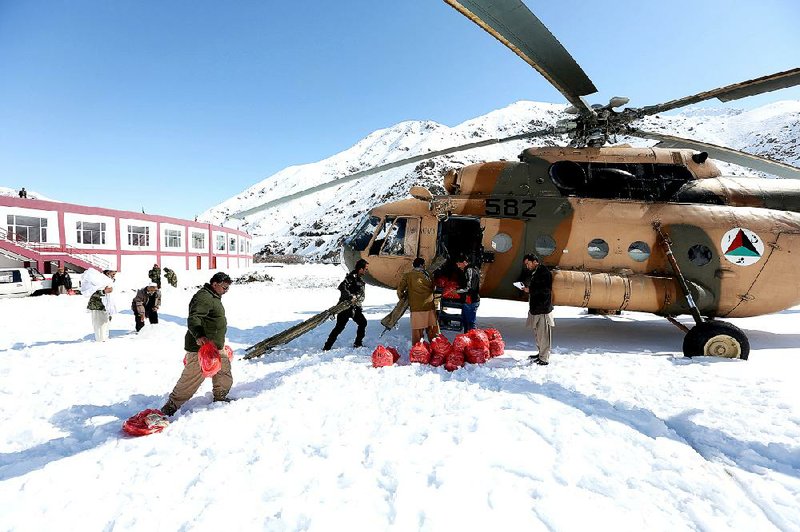 Afghans in avalanche-hit Panjshir province load a helicopter with food, water and blankets for survivors Friday. 