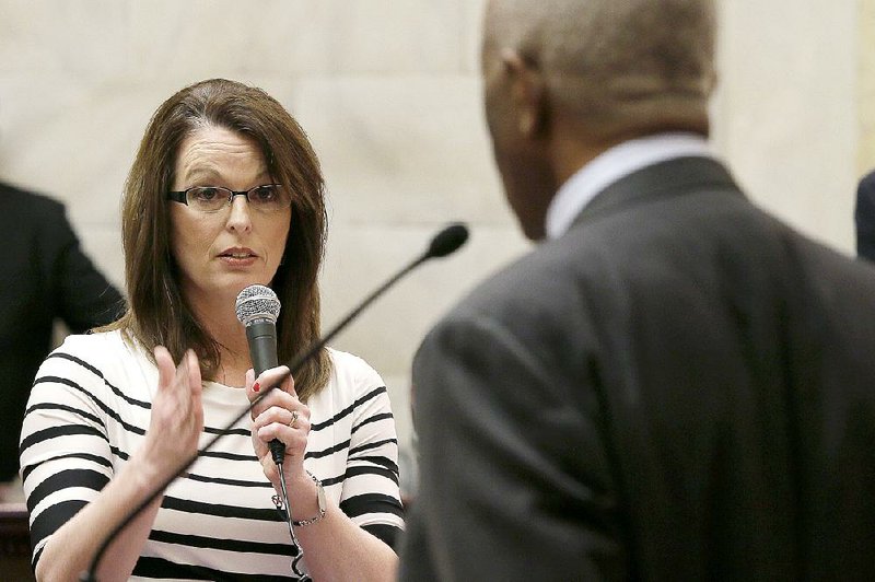 Rep. Julie Mayberry, R-Hensley, asks a question Friday of Rep. John Walker, D-Little Rock, on the floor of the House. Mayberry favored and Walker opposed legislation giving law enforcement access to certain cellphone data during emergencies; the proposal passed. 