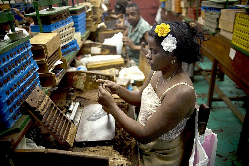 A cigar roller works Thursday at the Corona factory in Havana. Cuban officials expect to double on-island sales of hand-rolled cigars this year from 3 million to 6 million. 